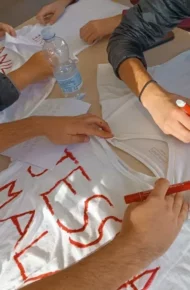 Nastri, magliette e visi dipinti: l’Othoca si colora di rosso contro la violenza di genere